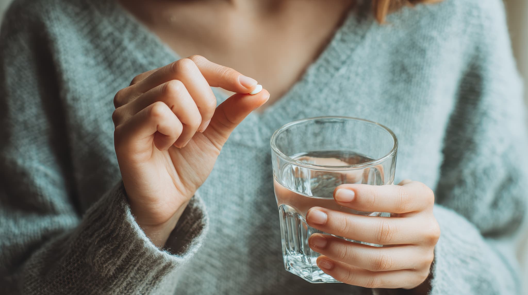 痛み止めを服用する女性