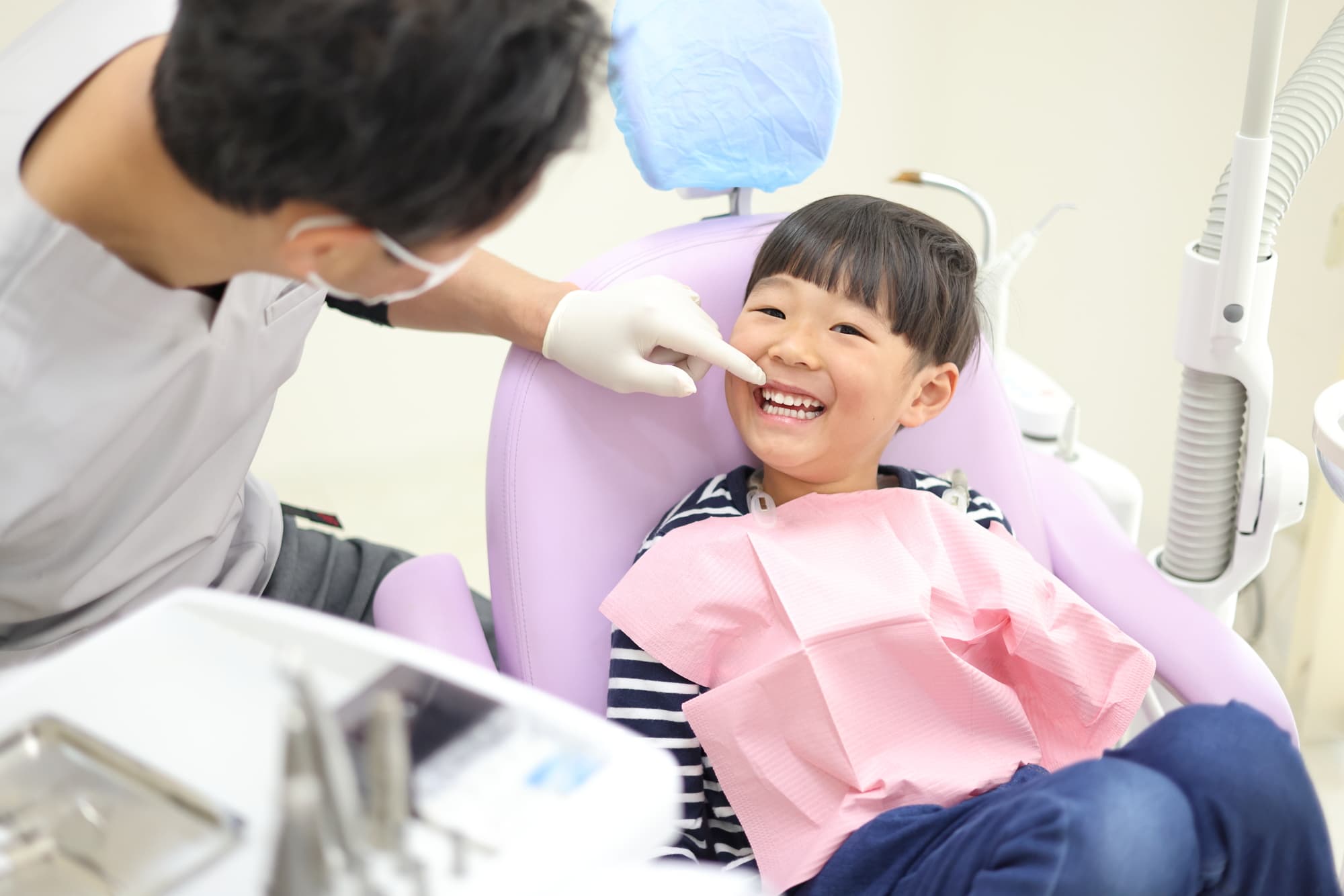 子どもの歯をチェックする歯科医師