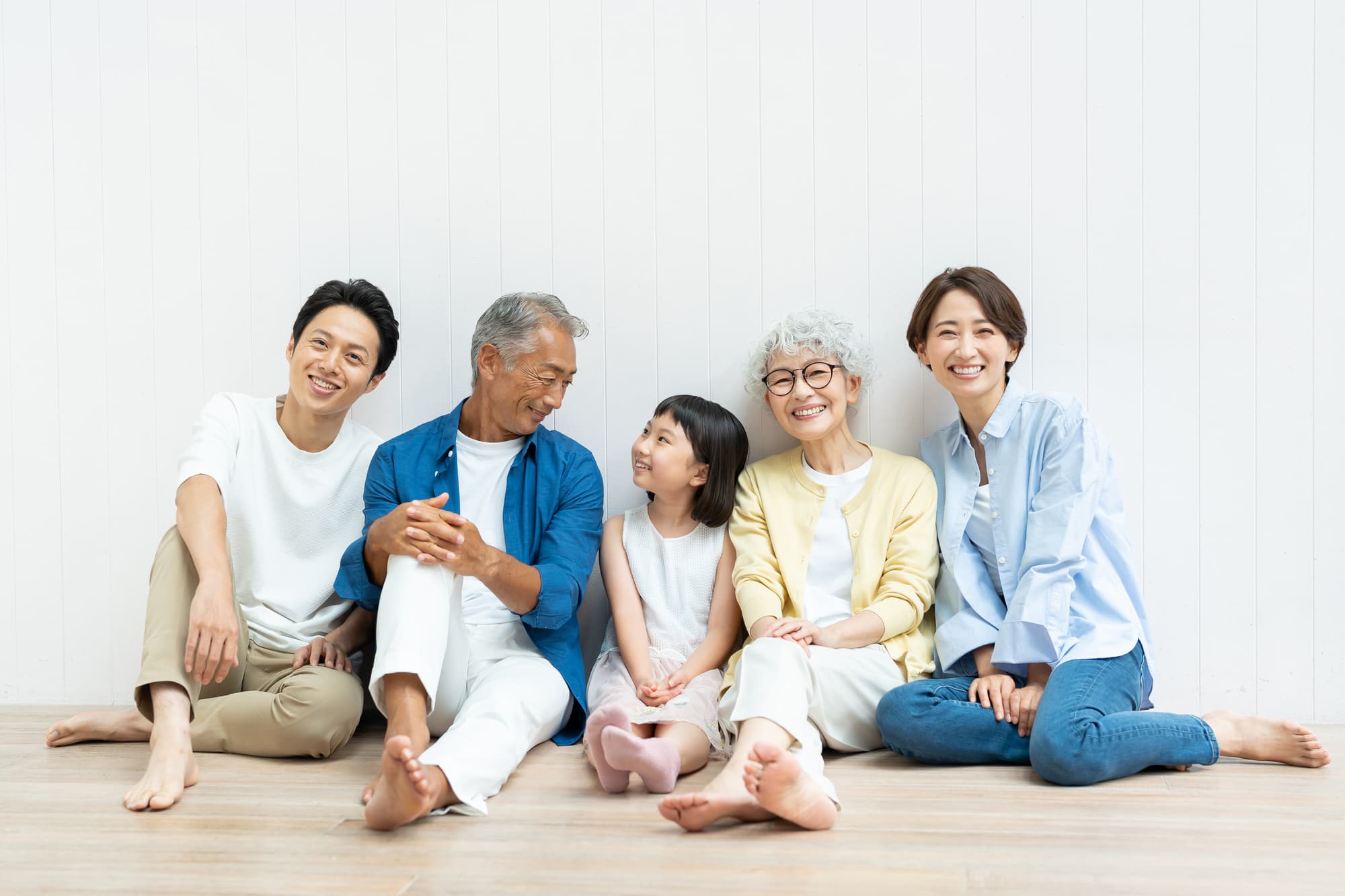 並んで座る笑顔の三世代家族