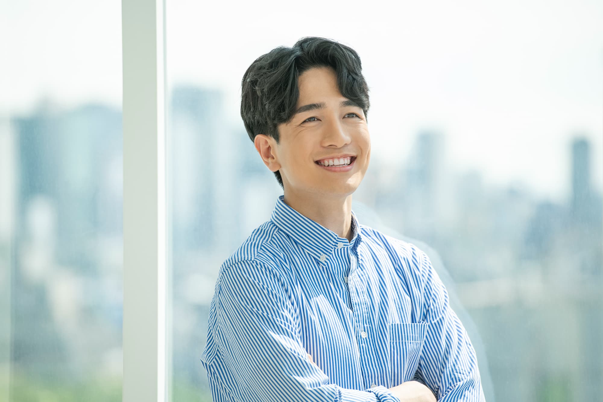 笑顔で腕を組む男性