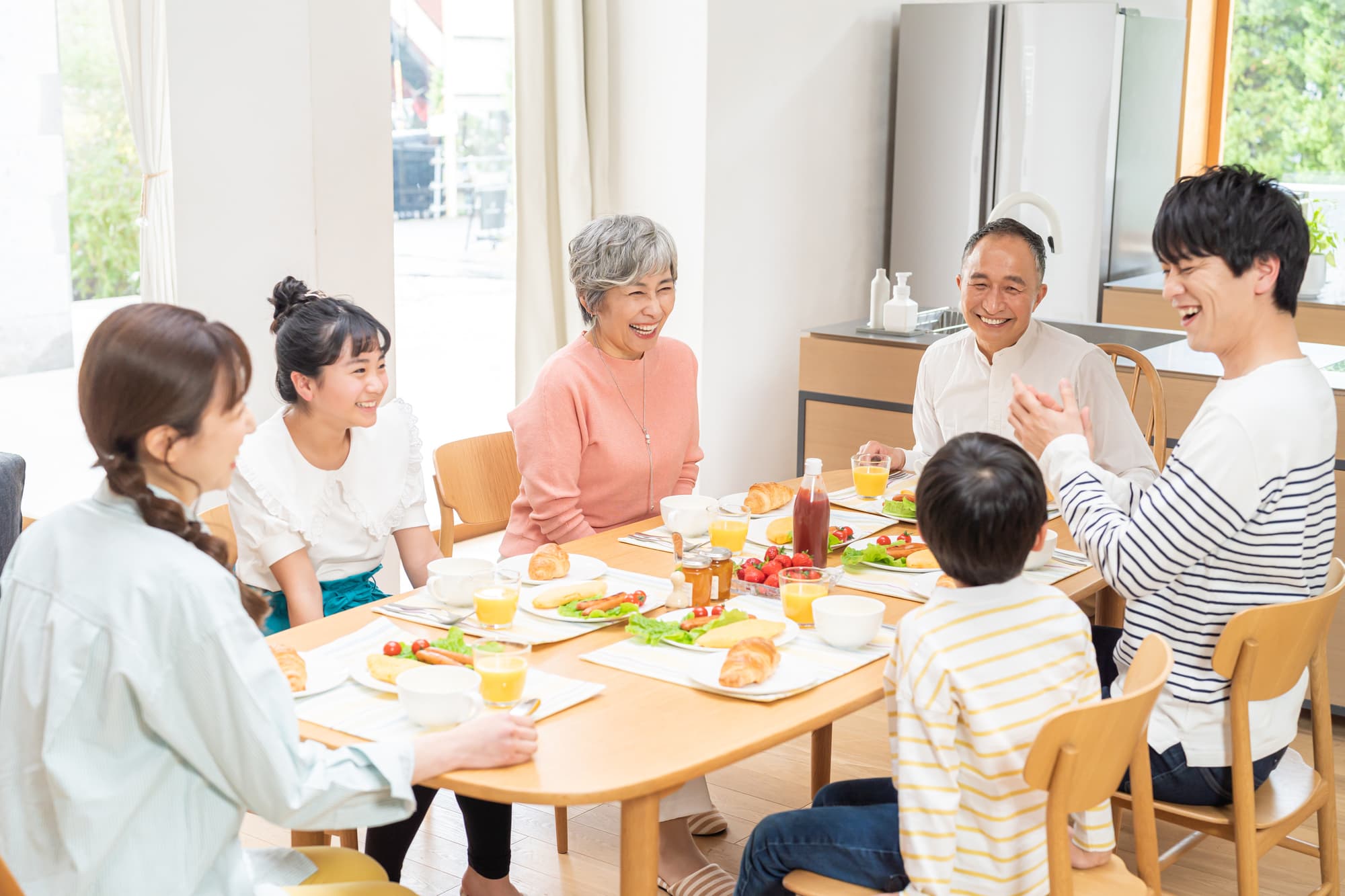 ダイニングで食事を楽しむ三世代家族