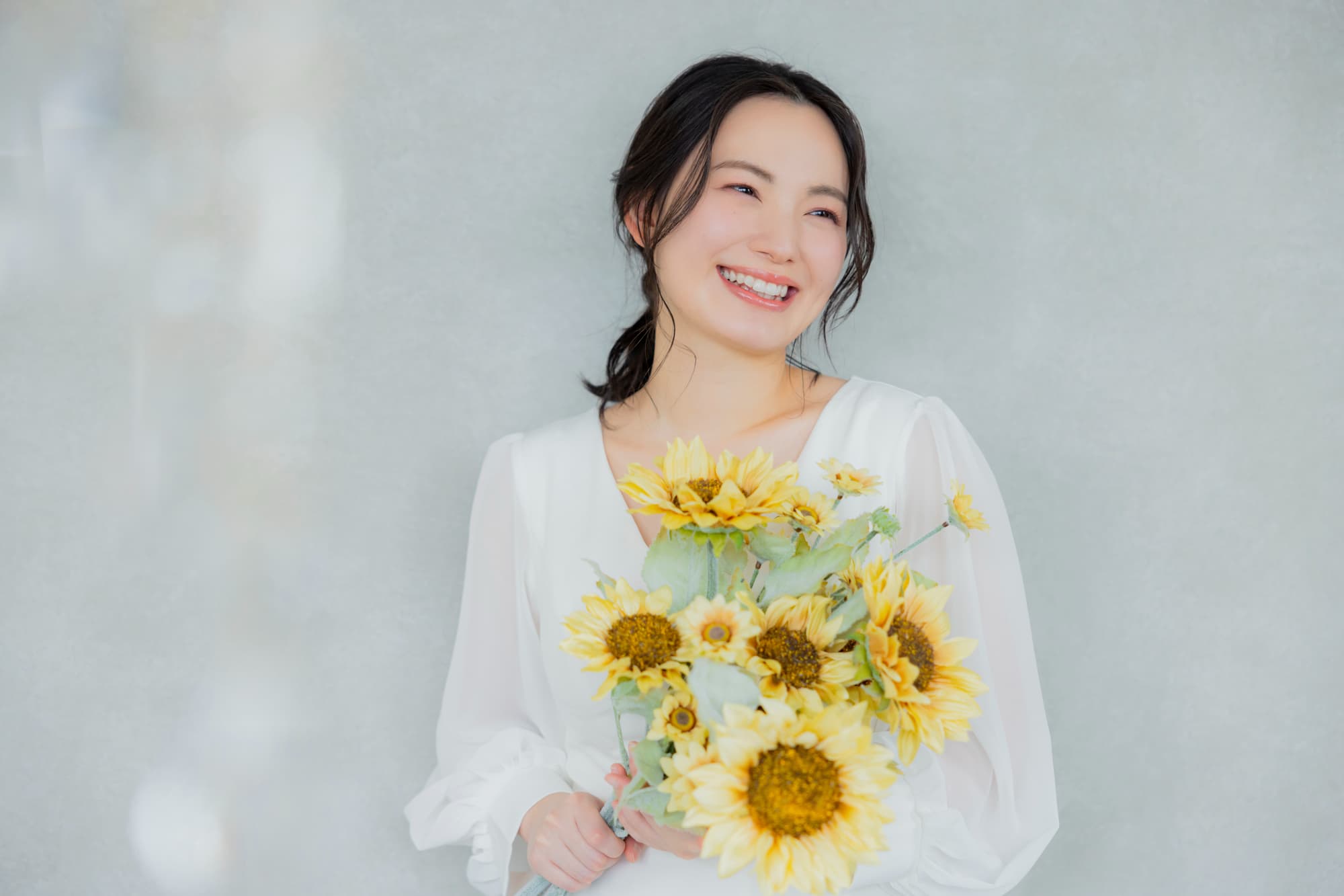 花束を持ち微笑む女性