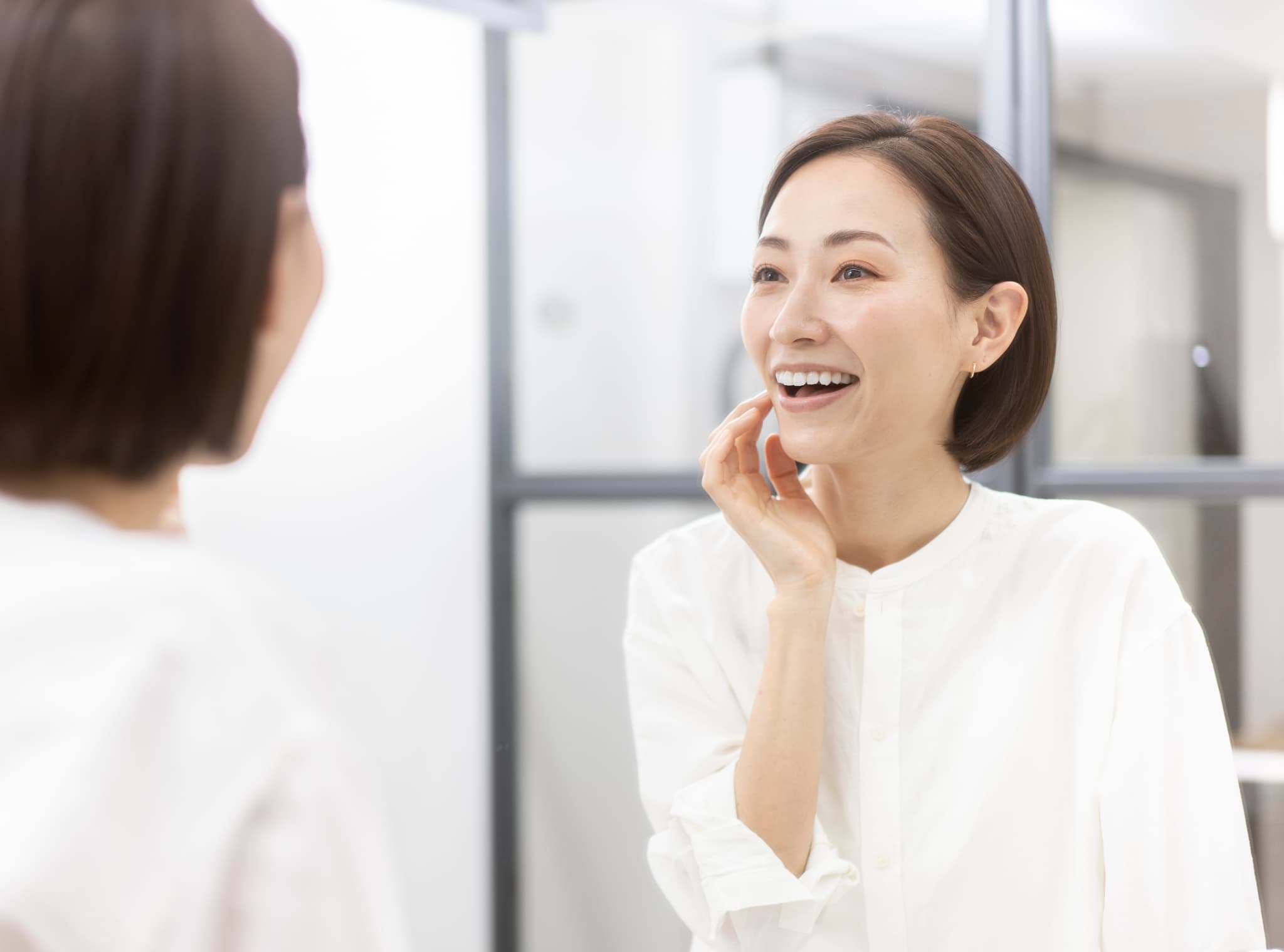 セラミックに変えた歯を確認して嬉しそうにほほ笑む女性