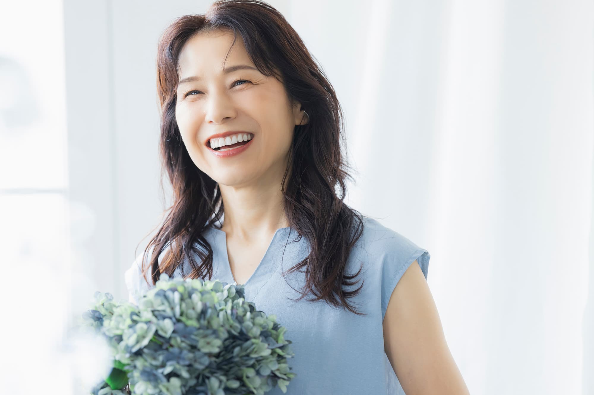 PMTCを受けて綺麗な歯になった笑顔のミドル女性