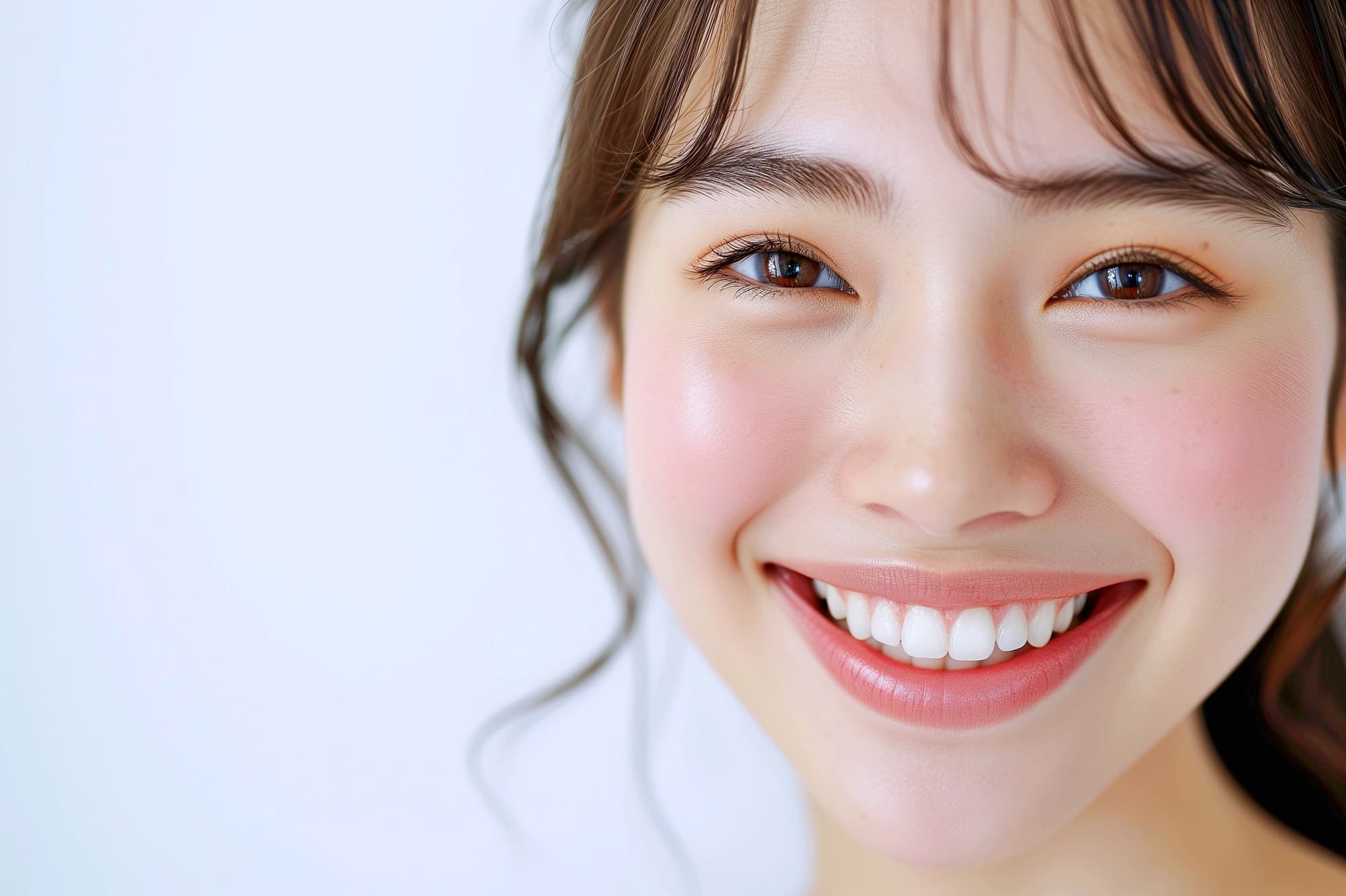 白い歯が印象的な明るい笑顔の女性