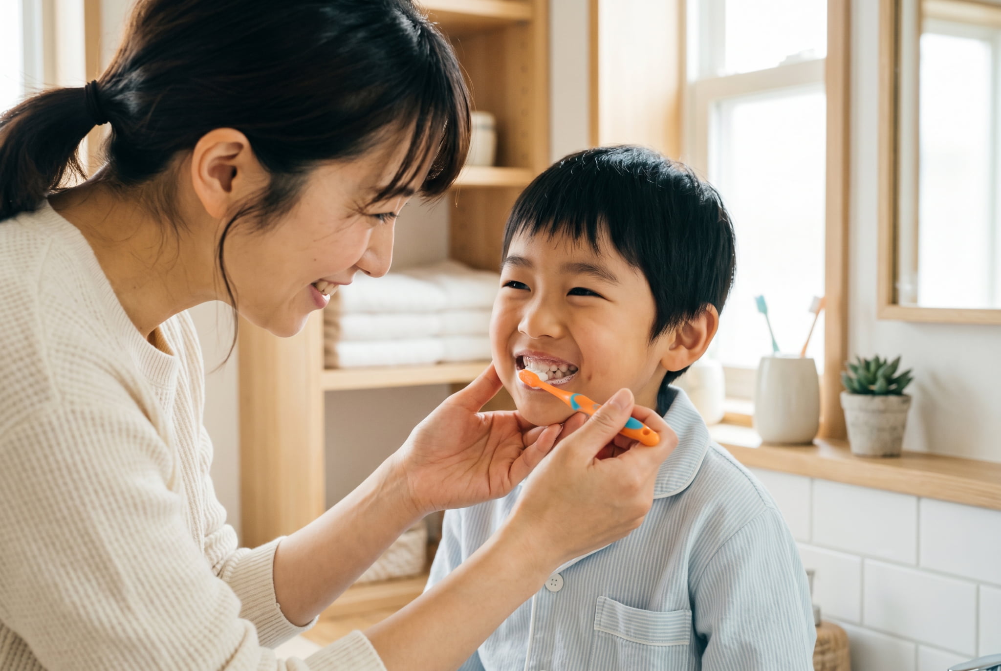母親に仕上げ磨きをしてもらう男の子